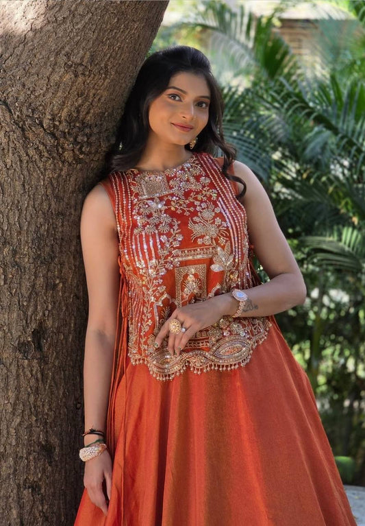 rust orange sleeveless lehenga with heavy gold embroidery and a flared silk skirt.