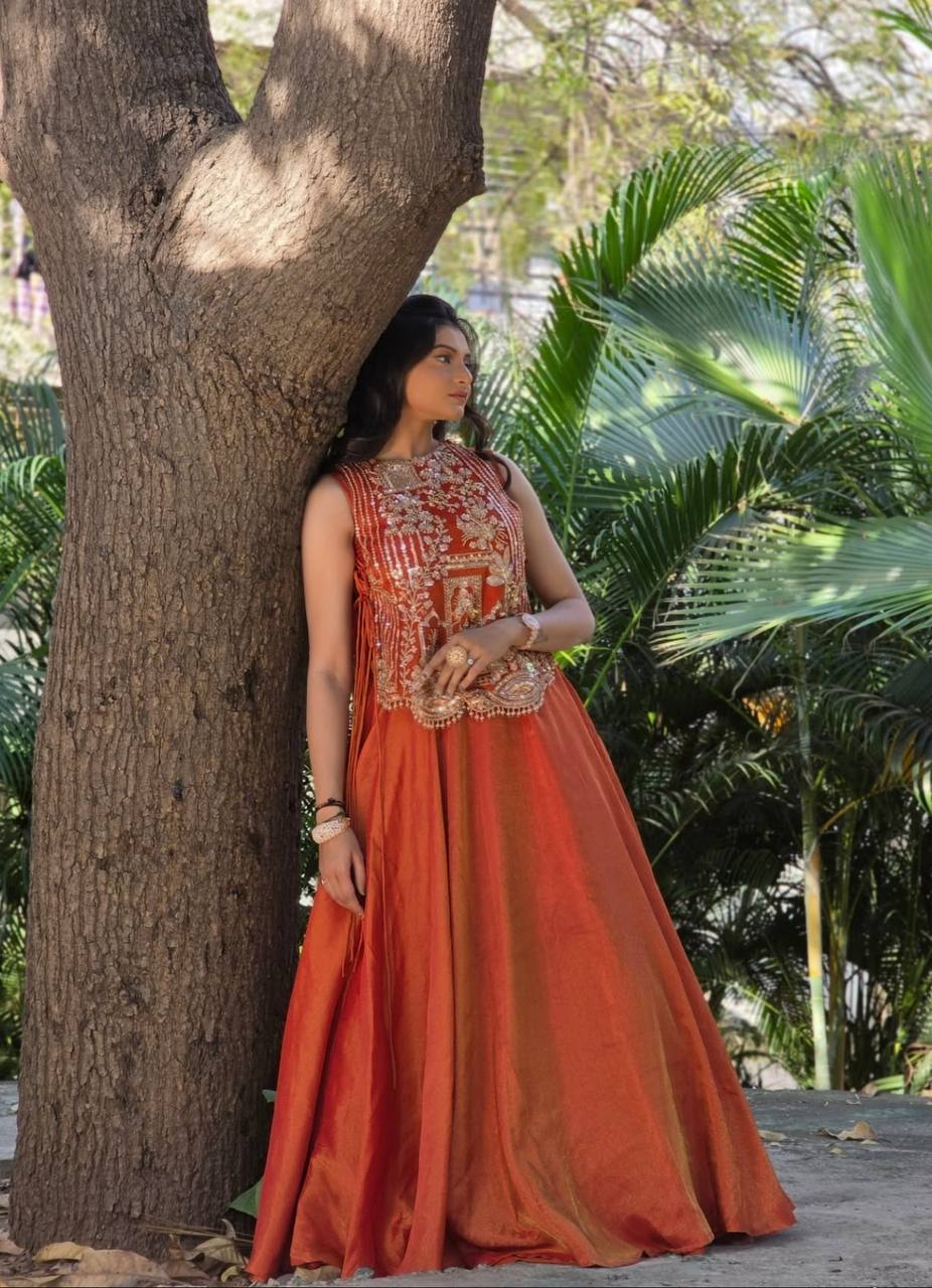 rust orange sleeveless lehenga with heavy gold embroidery and a flared silk skirt.