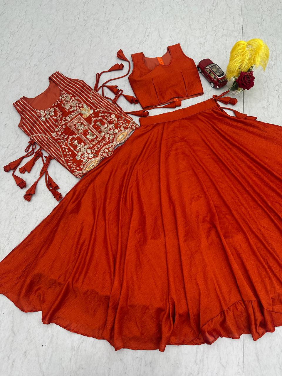 rust orange sleeveless lehenga with heavy gold embroidery and a flared silk skirt.